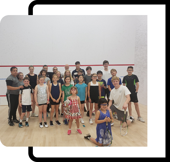 A group of people standing in front of a racquet.